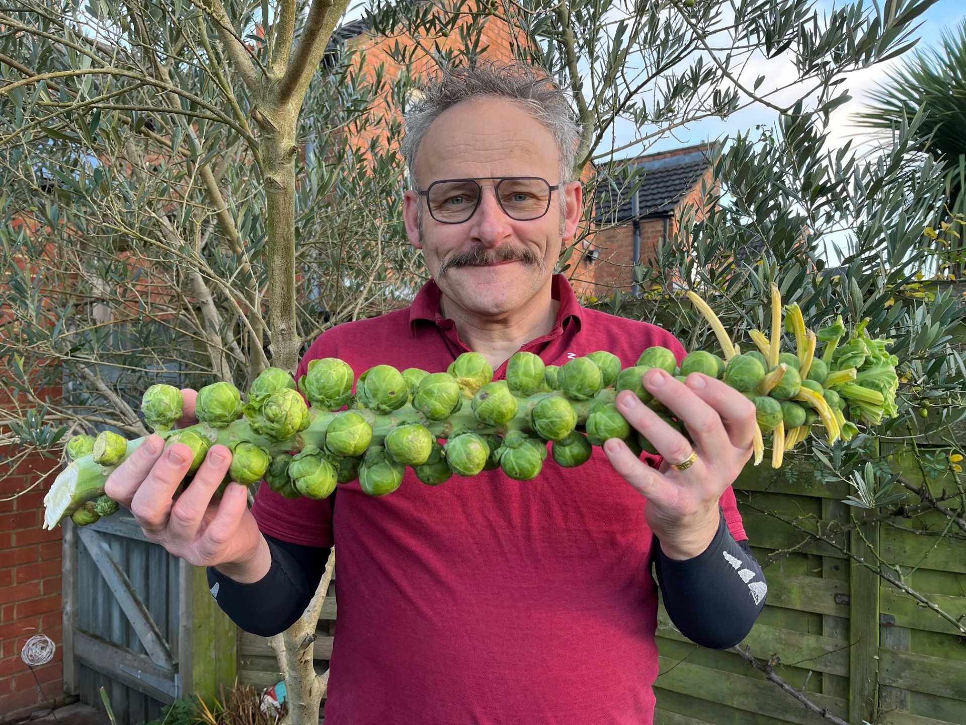 Image shows Duncan Murray holding a stalk of sprouts